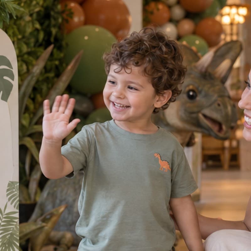 Menino acenando e sorrindo na festa